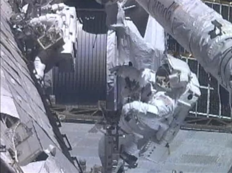 In this image from NASA TV, astronauts Greg Chamitoff (foreground) and Mike Fincke work outside the International Space Station repositioning the shuttle's Orbiter Boom Sensor System during the mission's fourth and final spacewalk Friday.